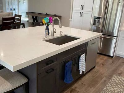 A kitchen with a sink , refrigerator , and dishwasher.