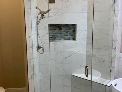A bathroom with a walk in shower and a sink.