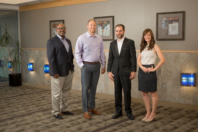 A group of people are standing next to each other in a room.