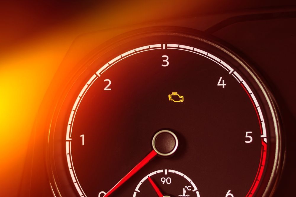 A close up of a speedometer with a yellow light on it