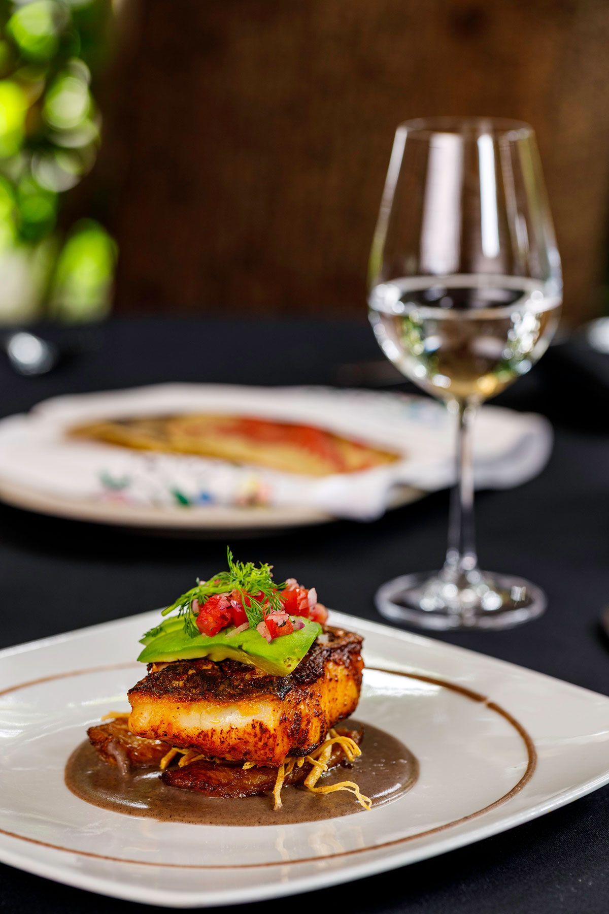 Plato gourmet con copa de vino de Azul Condesa