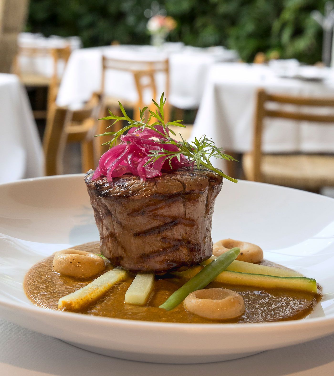 Medallón de filete emplatado con verduras y salsa