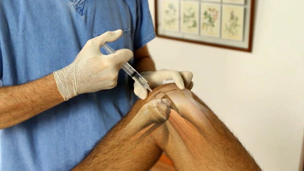 Un hombre recibe una inyección en la rodilla.
