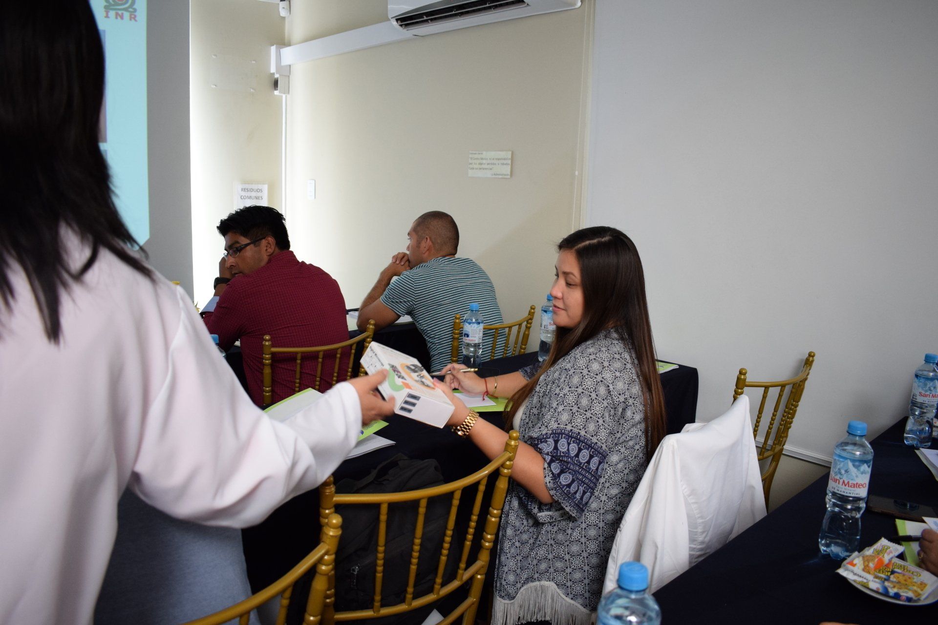 Un grupo de personas están sentadas en mesas en una habitación.
