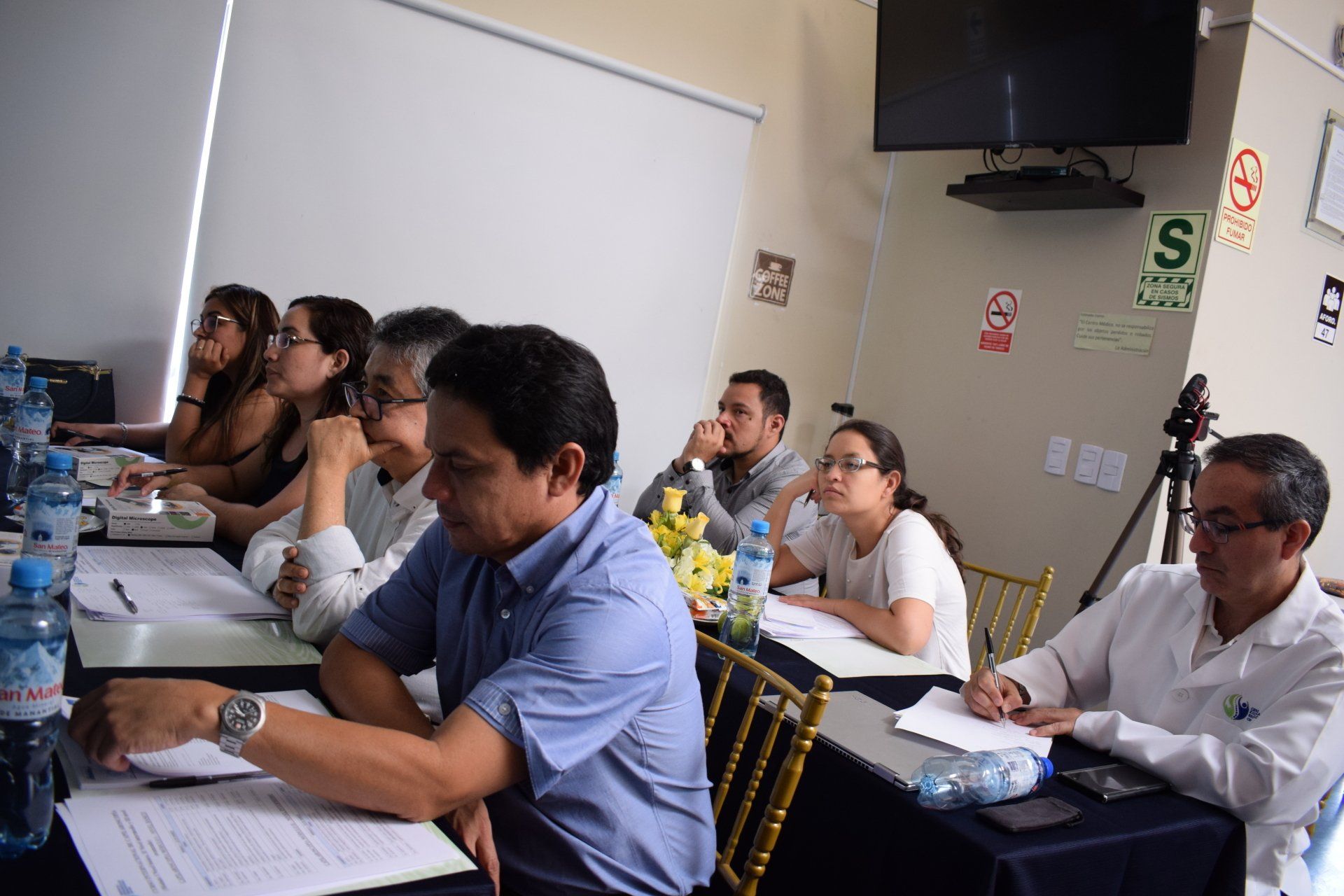 Un grupo de personas están sentadas en mesas en una habitación.