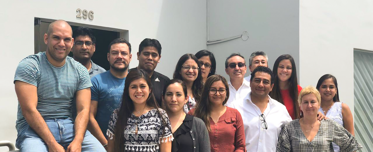 Un grupo de personas posan para una fotografía frente a un edificio.