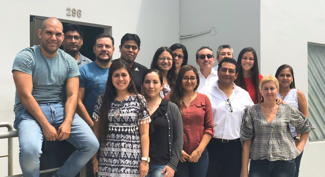 Un grupo de personas posan para una fotografía frente a un edificio.