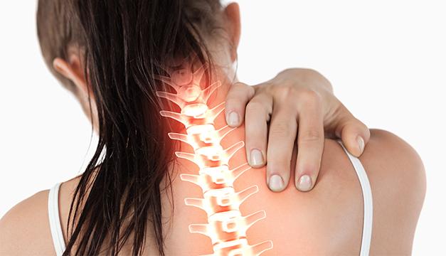 Una mujer se sostiene el cuello y el hombro por el dolor.