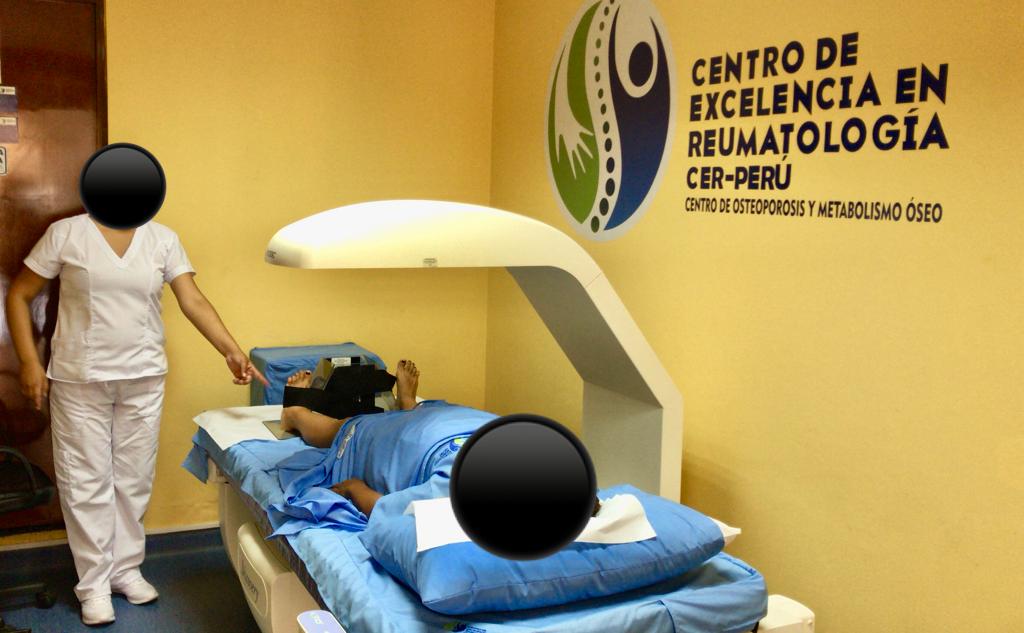 Una persona está acostada en una cama en una habitación que dice centro de excelencia en reumatología