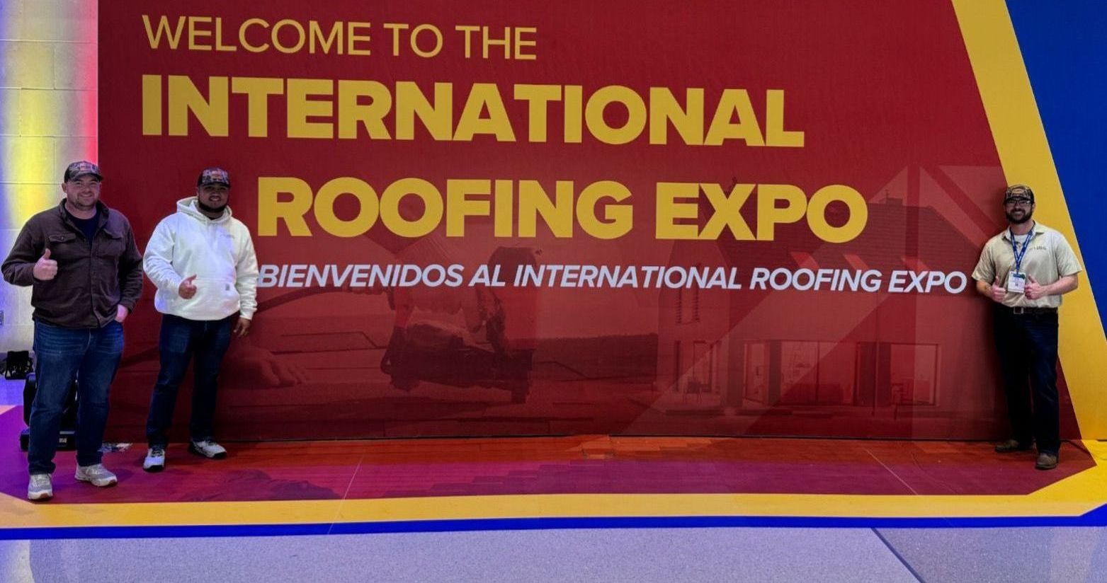 Three men are standing in front of a sign that says welcome to the international roofing expo.