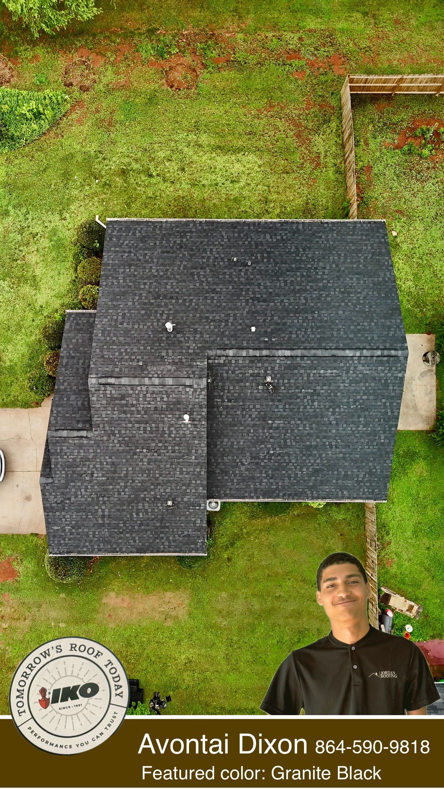 Aerial view of a house with a dark roof, grassy yard, and a person standing at the bottom right.