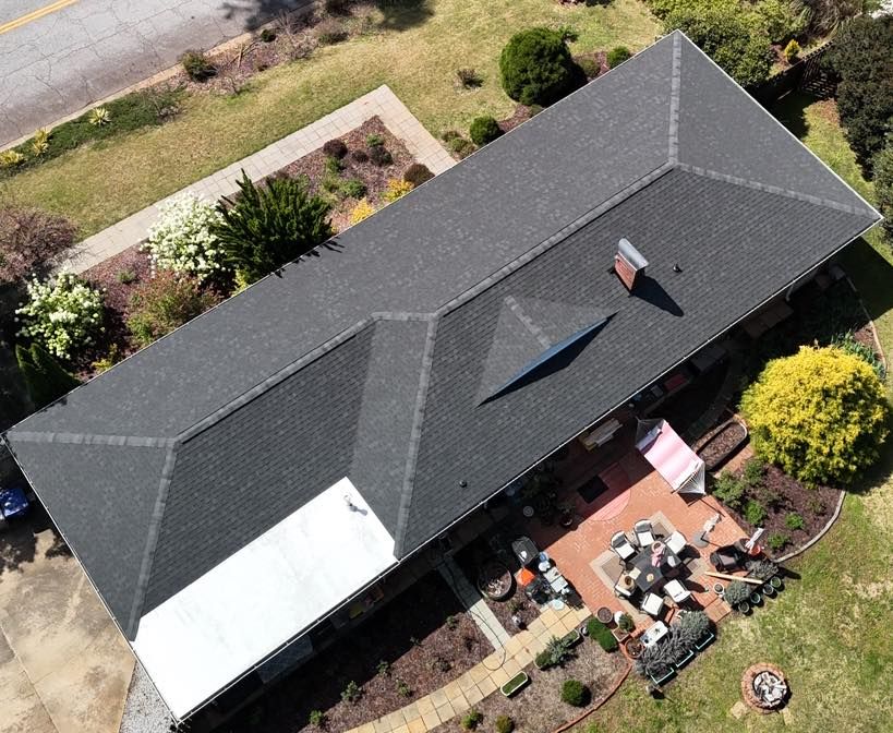 An aerial view of a house with a black roof