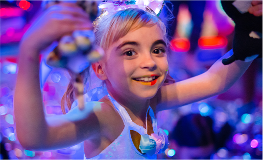 A little girl wearing a unicorn outfit is smiling