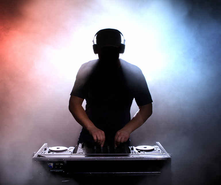 A silhouette of a dj wearing headphones playing music