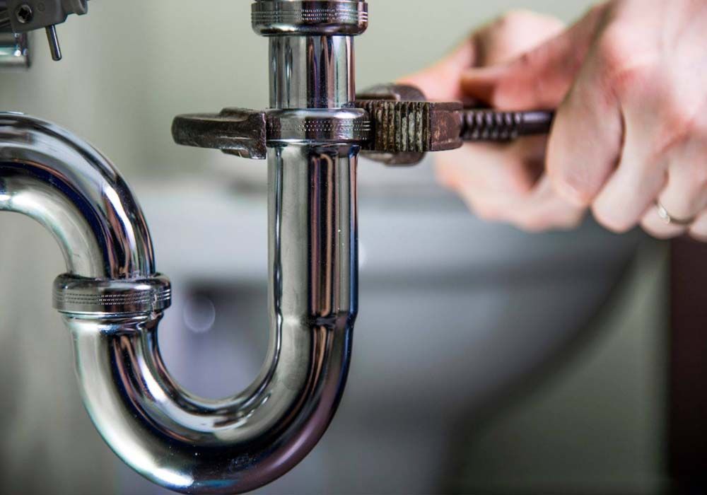 plumber tightening up pipes