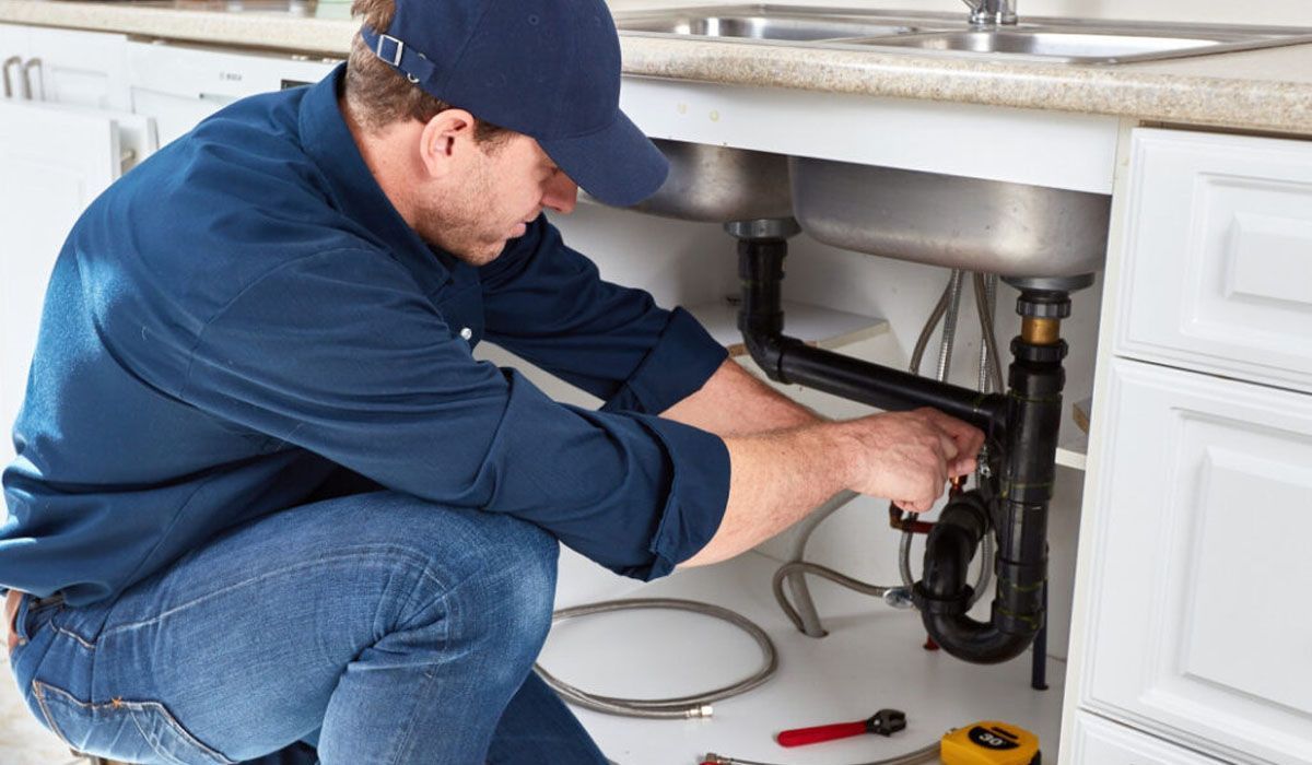 plumber working under a sink