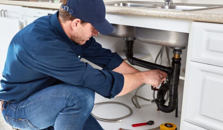 plumber working under a sink