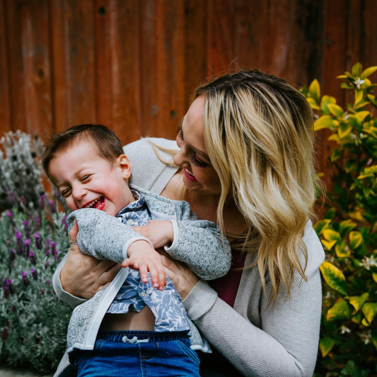 Mother laughing, holding her young son.