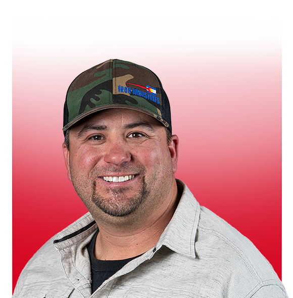 Smiling man in a camo cap and light gray shirt against a red gradient background