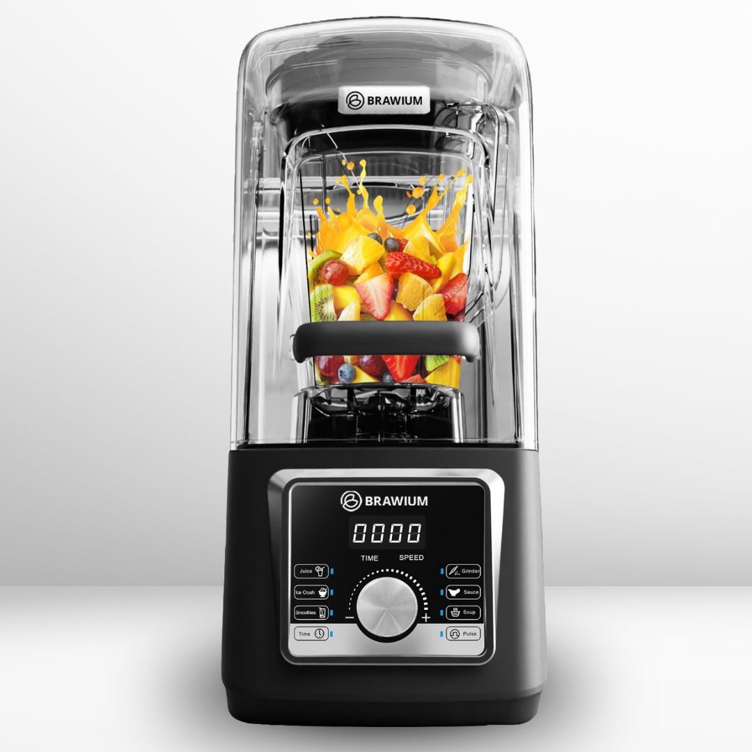 Blender hitam dengan wadah bening berisi buah; cipratan.