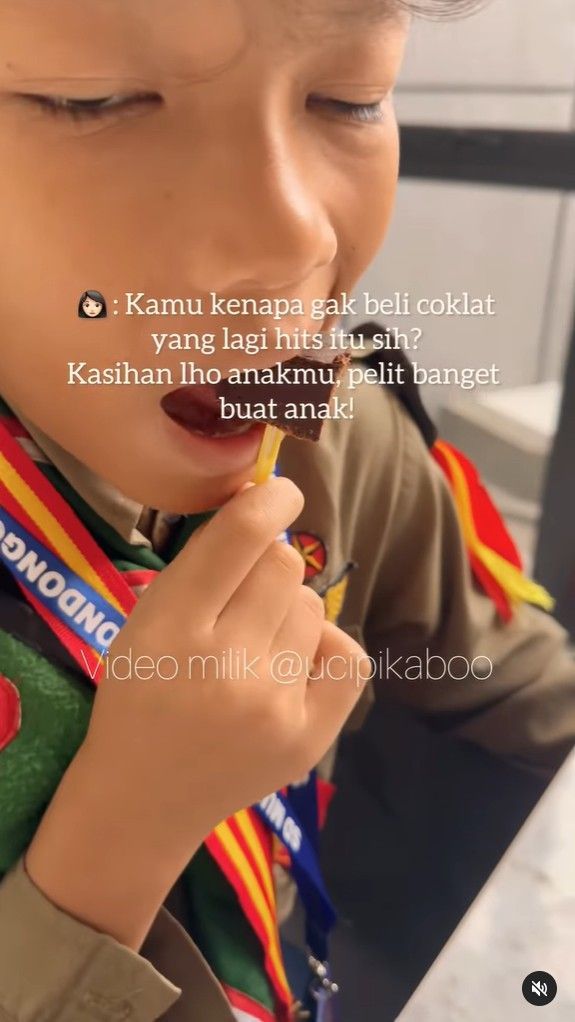 Seorang anak berseragam pramuka sedang menikmati cokelat. Close-up, dengan hamparan teks.