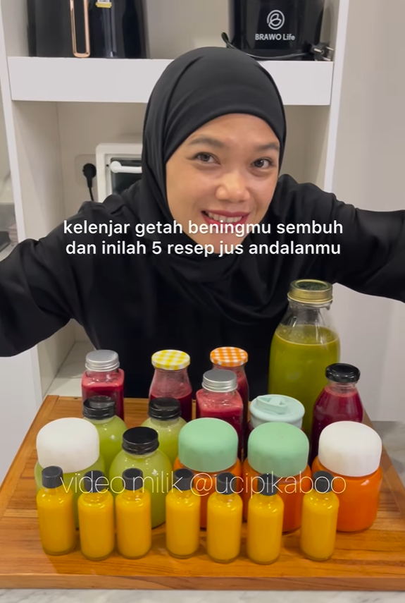 Wanita berhijab memegang jus, teks tentang 5 resep. Jus dalam botol di atas permukaan kayu.