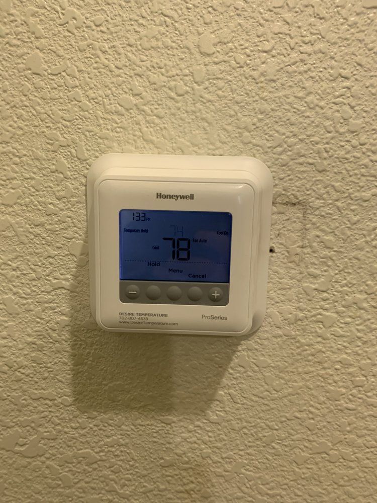 A white Honeywell Pro Series digital thermostat mounted on a textured, off-white wall displaying a temperature of 78 degrees.