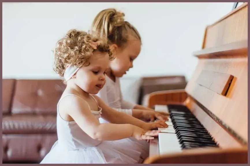 Two children playing piano together in a bright living room
