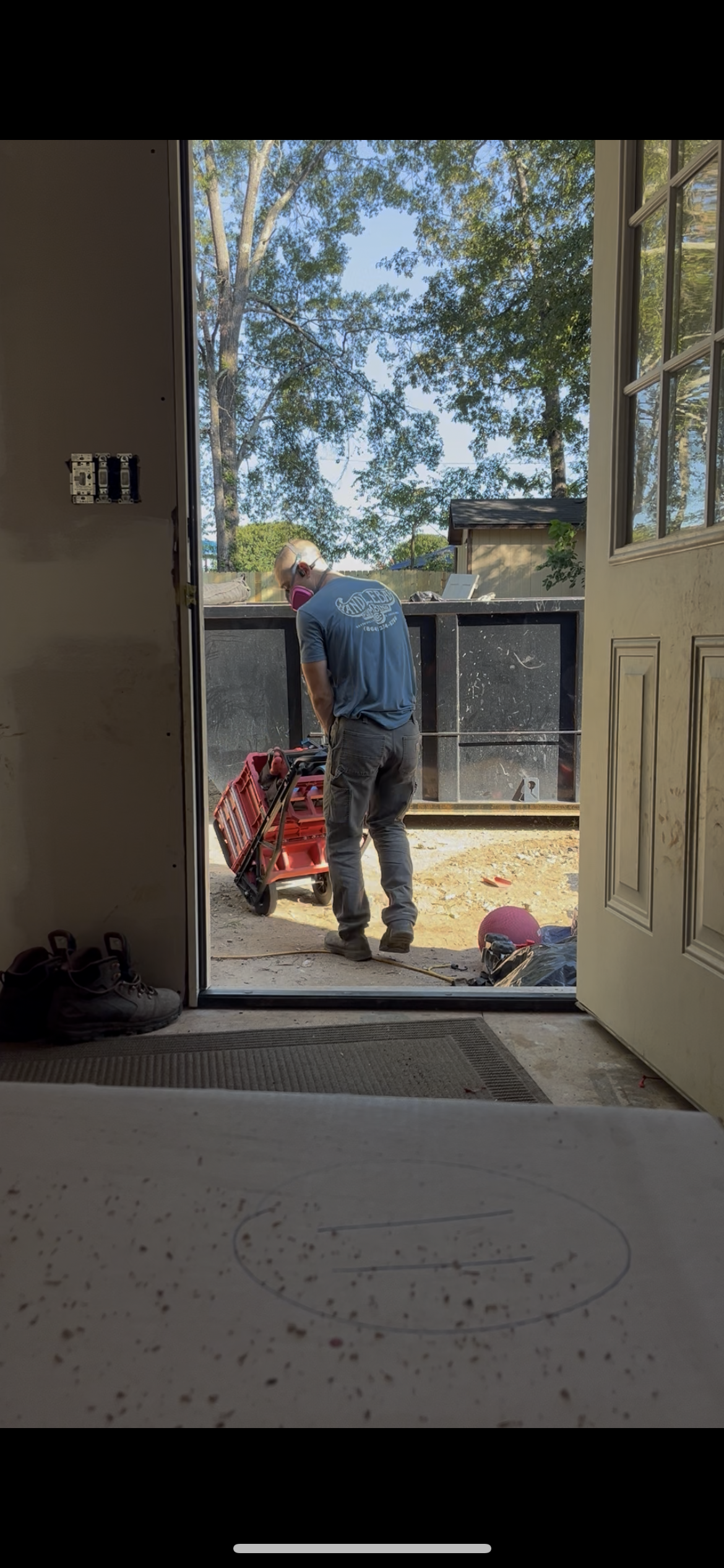 Plumber kneeling on street, working on pipes near his van.