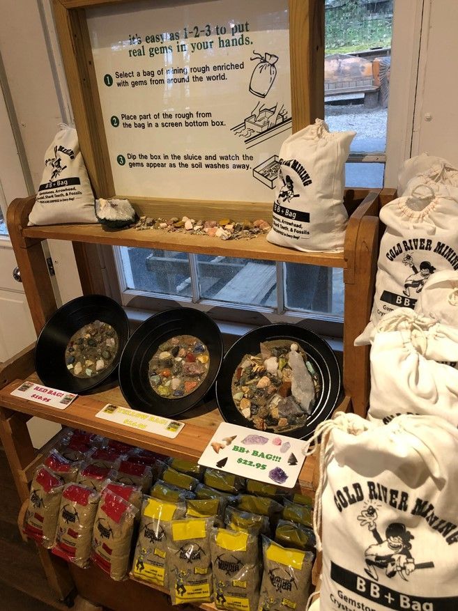 Display of Ohio-themed gifts and snacks on shelves at a shop, with baskets, bags, and framed sign.