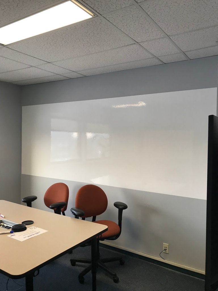 Une salle de conférence avec un tableau blanc et des chaises