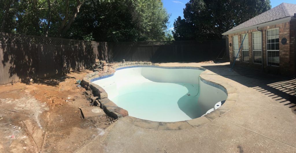 A large swimming pool in the backyard of a house.