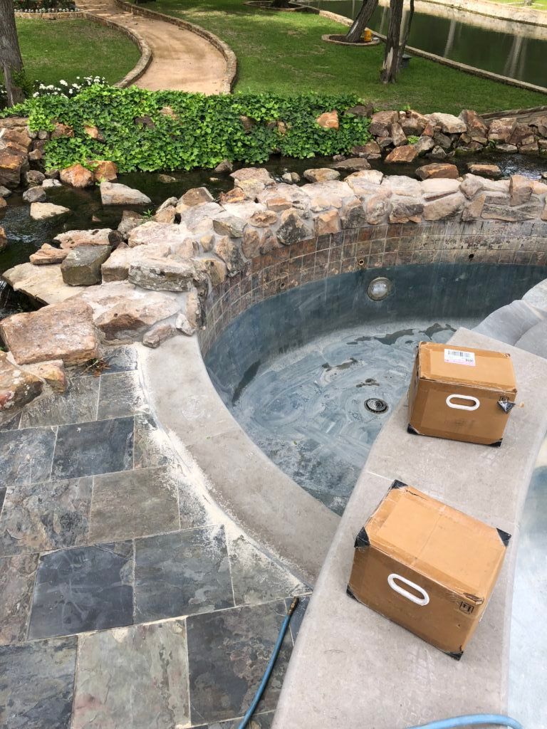 Two cardboard boxes are sitting next to a swimming pool.