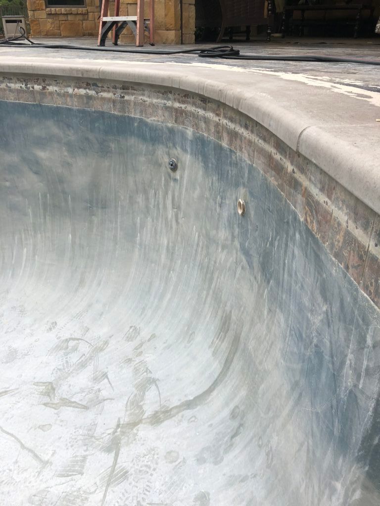 A close up of a swimming pool with a ladder in the background.