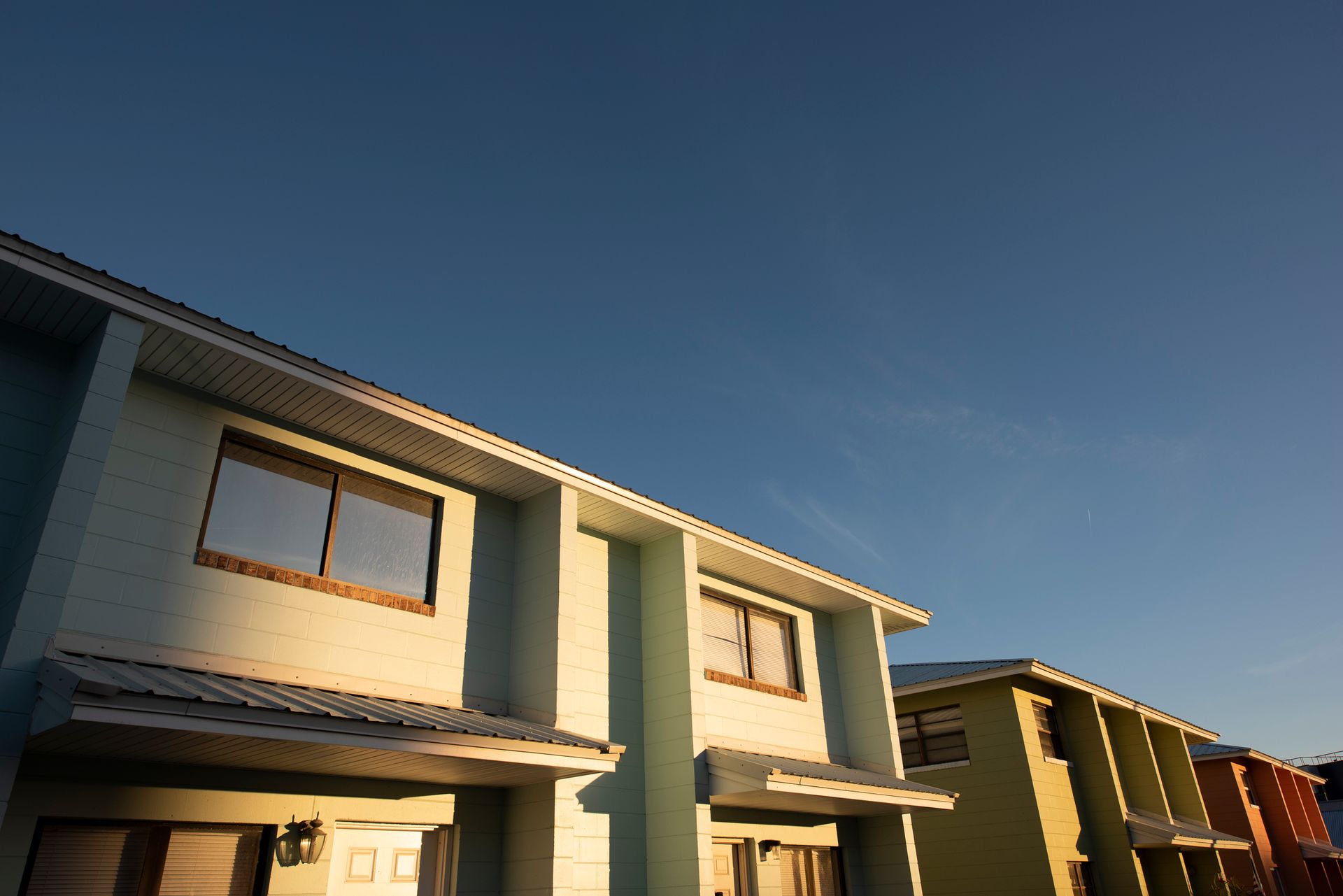 Row of colorful townhouses with a clear blue sky in the background.