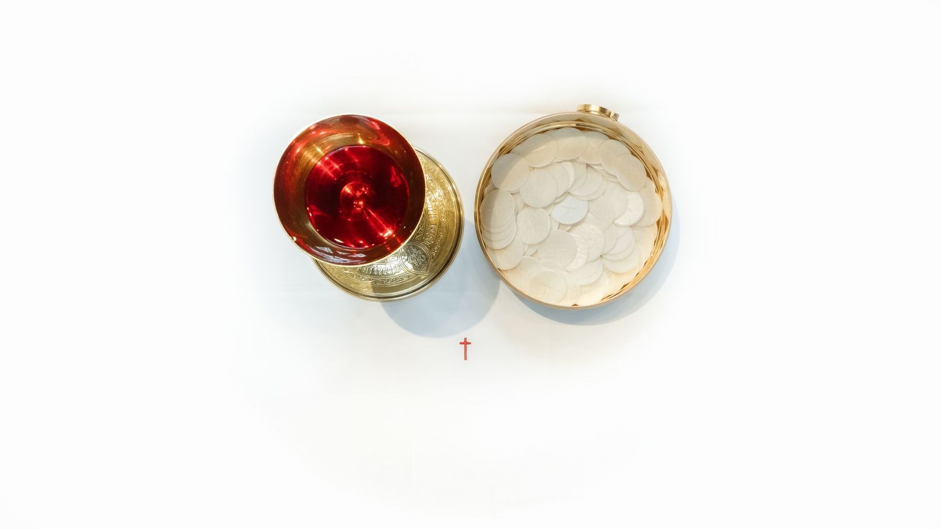 Top view of a gold and red decorative candle holder and its lid on a white background.