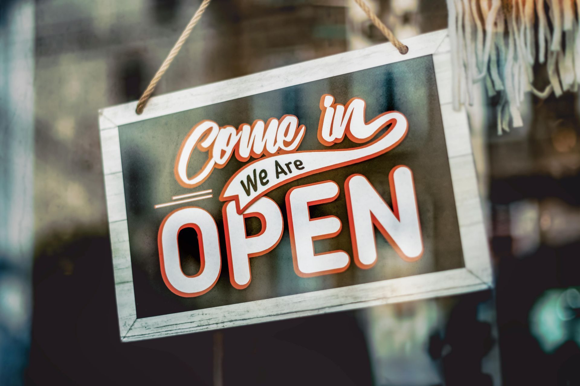 Open sign in a shop window, says 