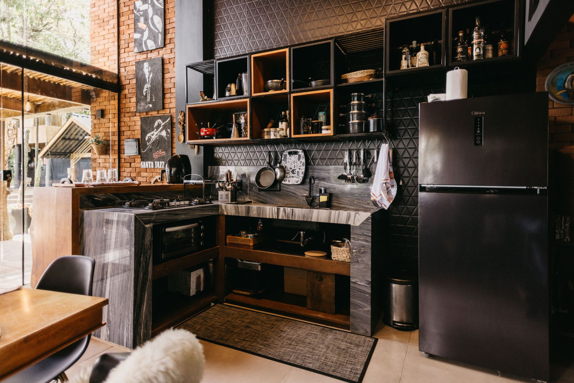 Modern kitchen with dark cabinets, open shelving, and a black refrigerator