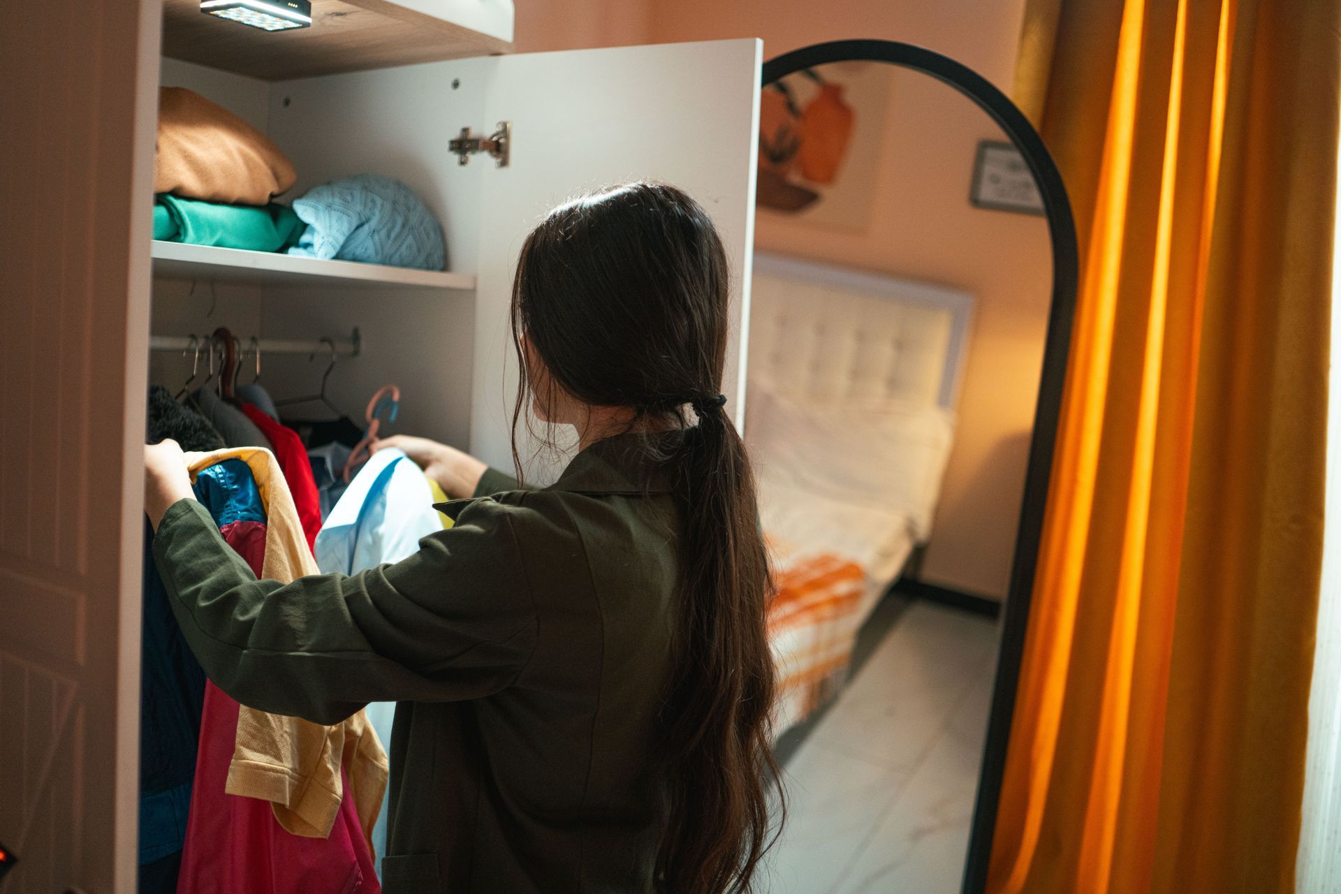 Woman hanging clothes in an open closet