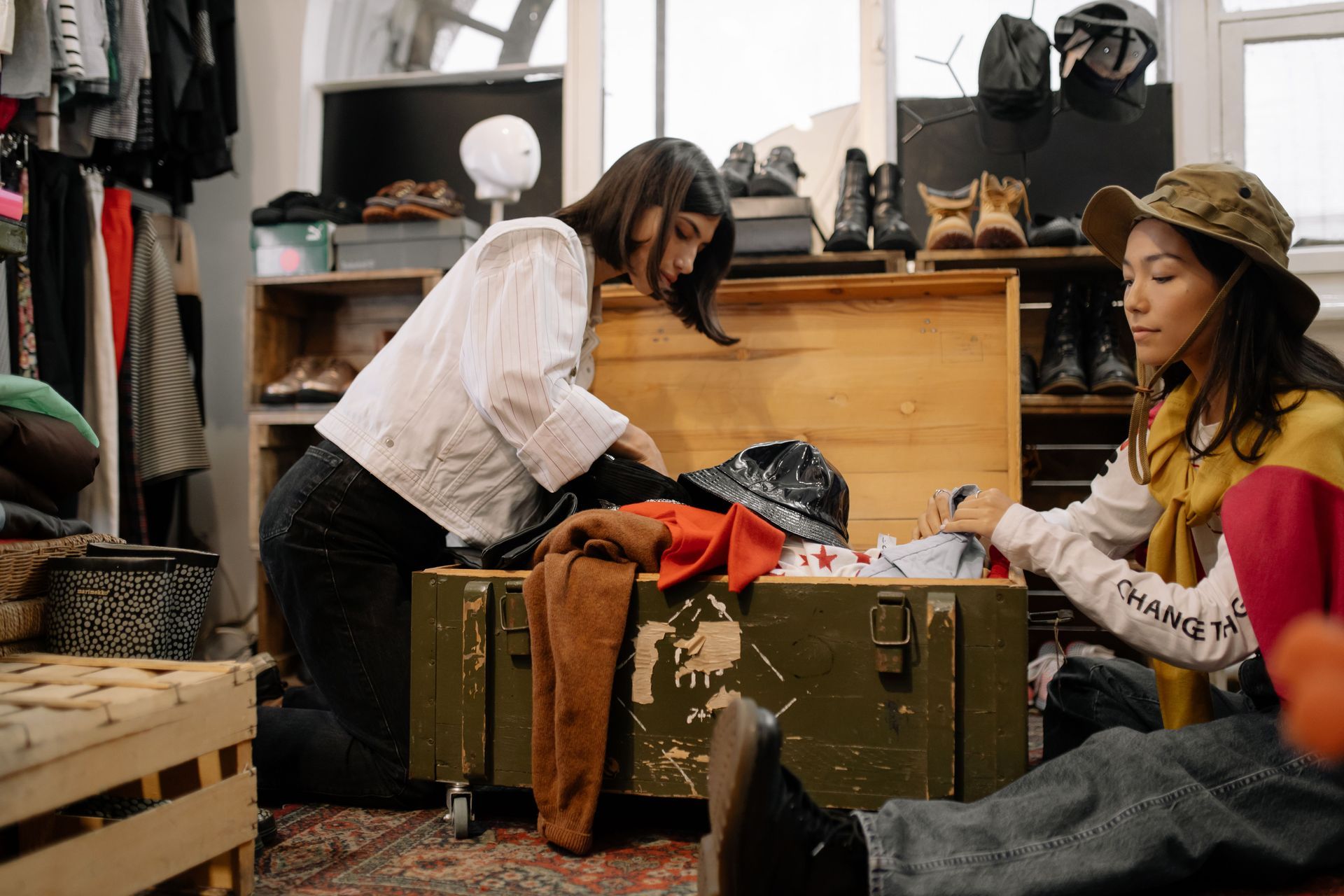 Two women sorting and packing clothes into an open suitcase
