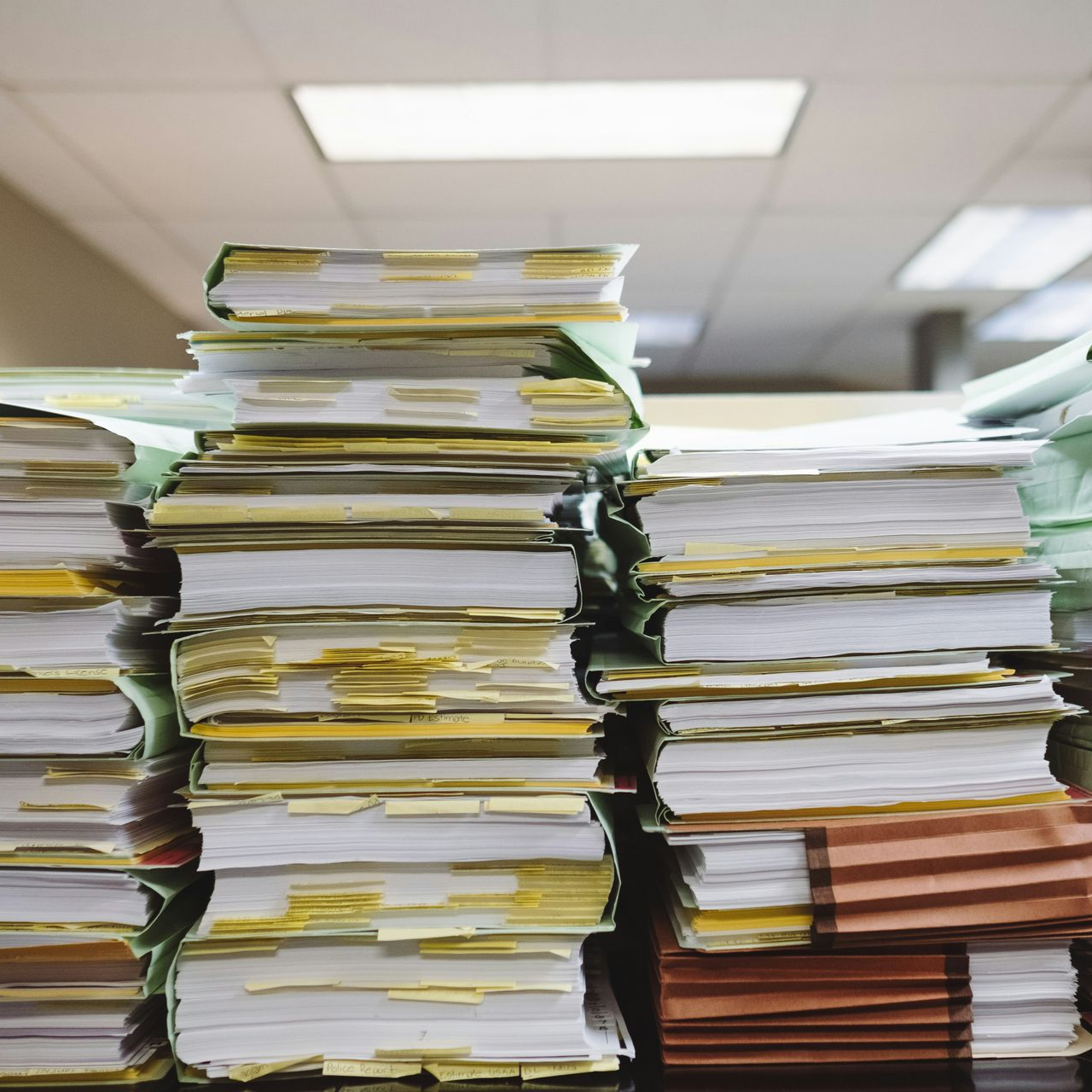 Stacks of paper documents and files highlighting the challenges of paper overload in office environments