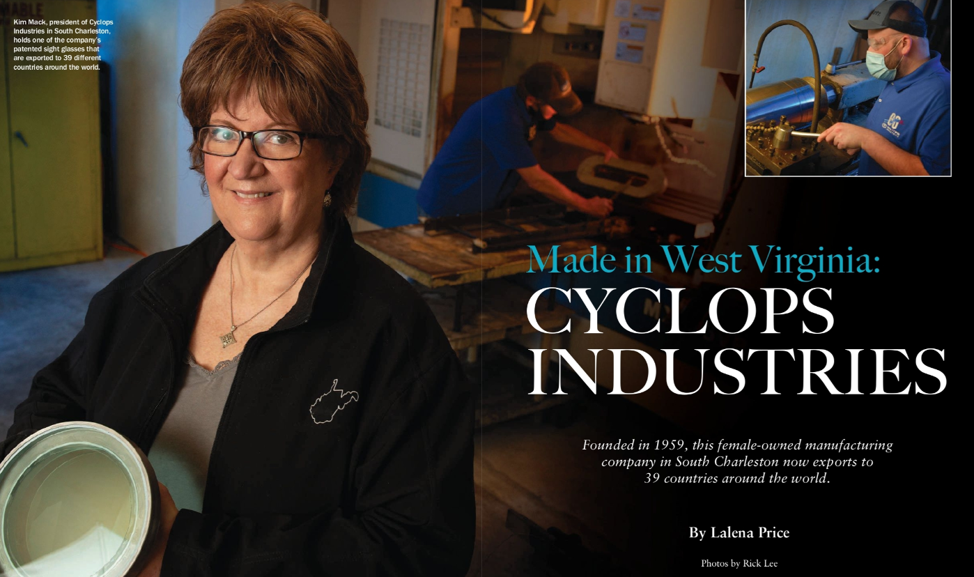 A woman is holding a white object in front of a picture of cyclops industries