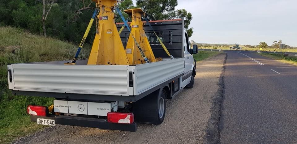 Truck With Two Yellow Jacks in the Back is Parked on the Side of the Road — Pit Express in Tomago, NSW