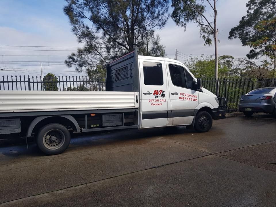 White Truck With a Flat Bed is Parked on the Side of the Road — Pit Express in Muswellbrook, NSW