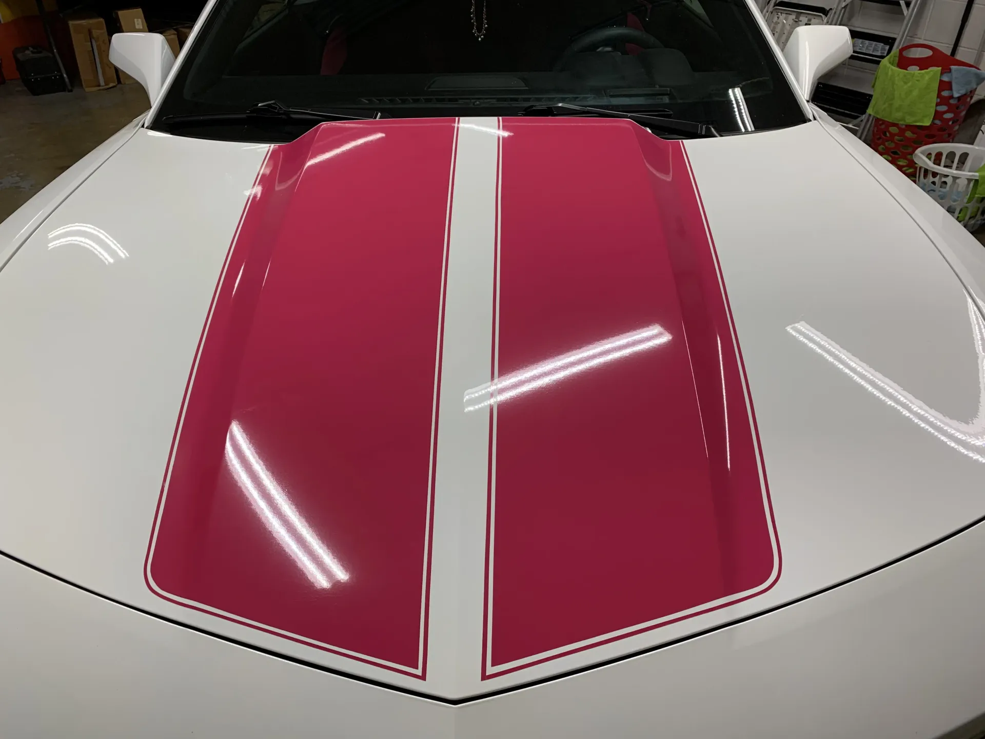 White car hood with pink racing stripes and thin white outlines.