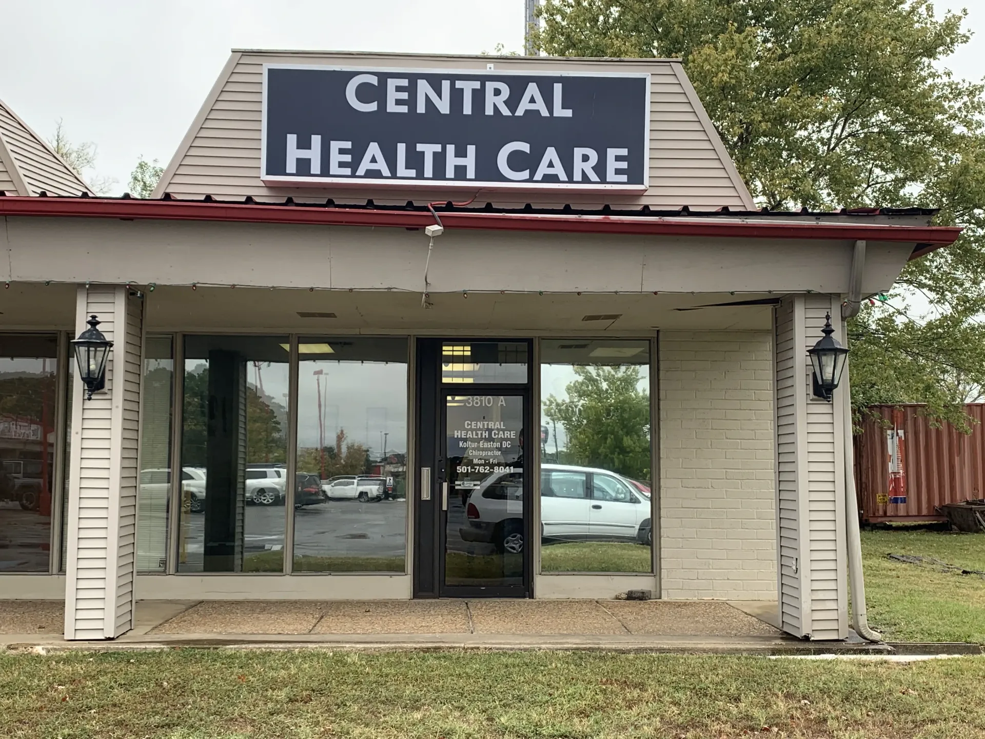 Central Health Care building with sign above door, cloudy sky.