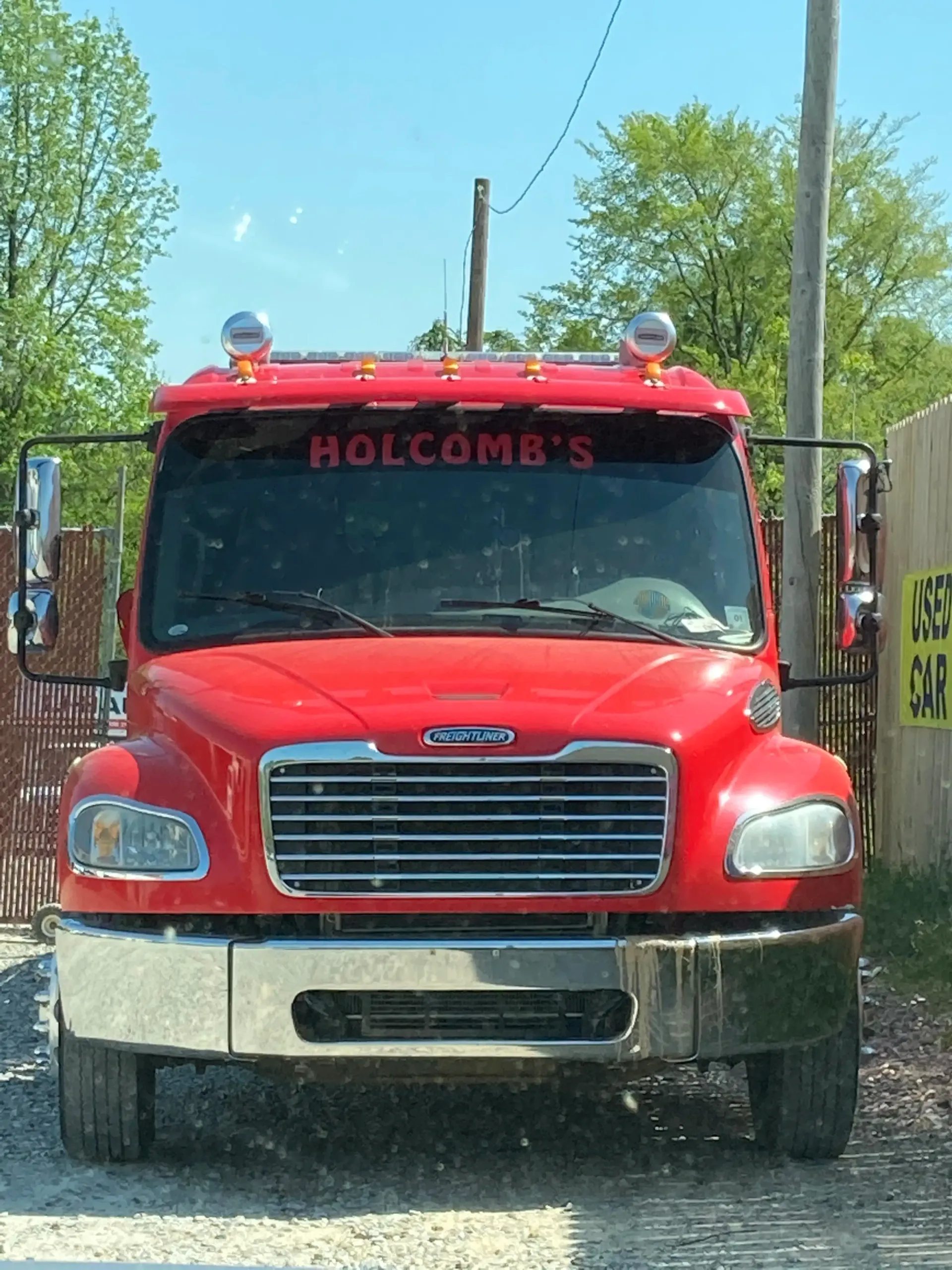 Red Holcomb's tow truck parked, front view. Chrome bumper, windshield banner, and side mirrors.