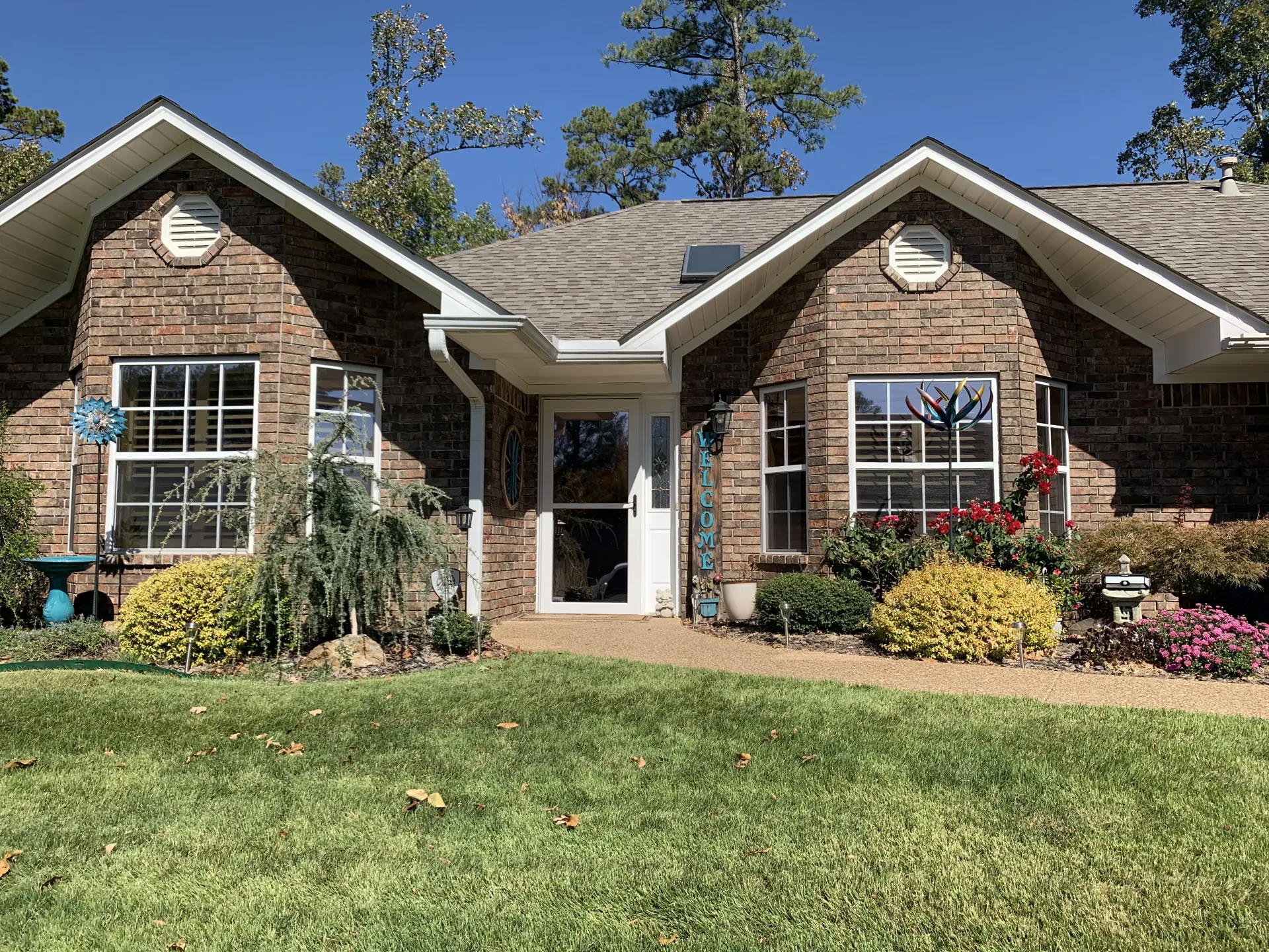 Brick house with white trim, arched windows, and a green lawn.