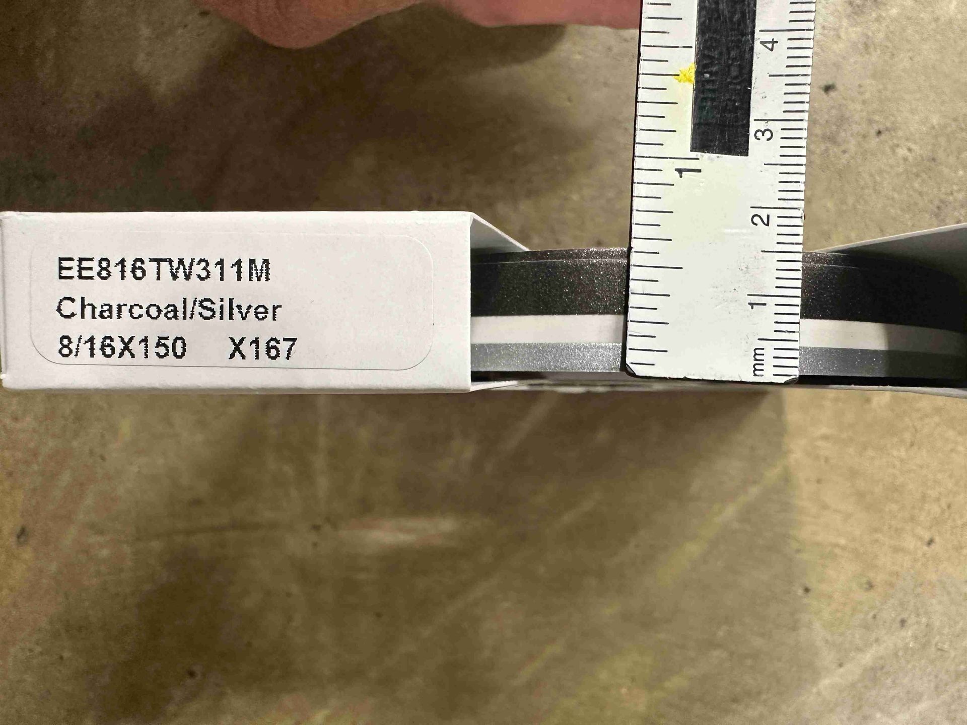 1/2 inch pinstriping A ruler measures a charcoal and silver colored item inside a white box.