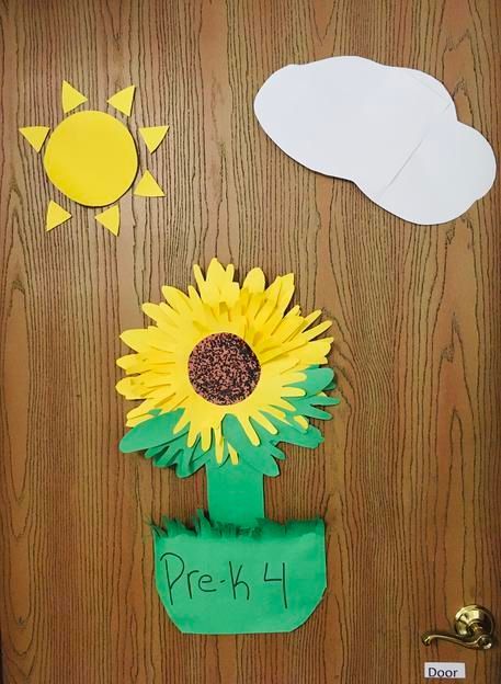 A wooden door with a sunflower and the word pre-k on it